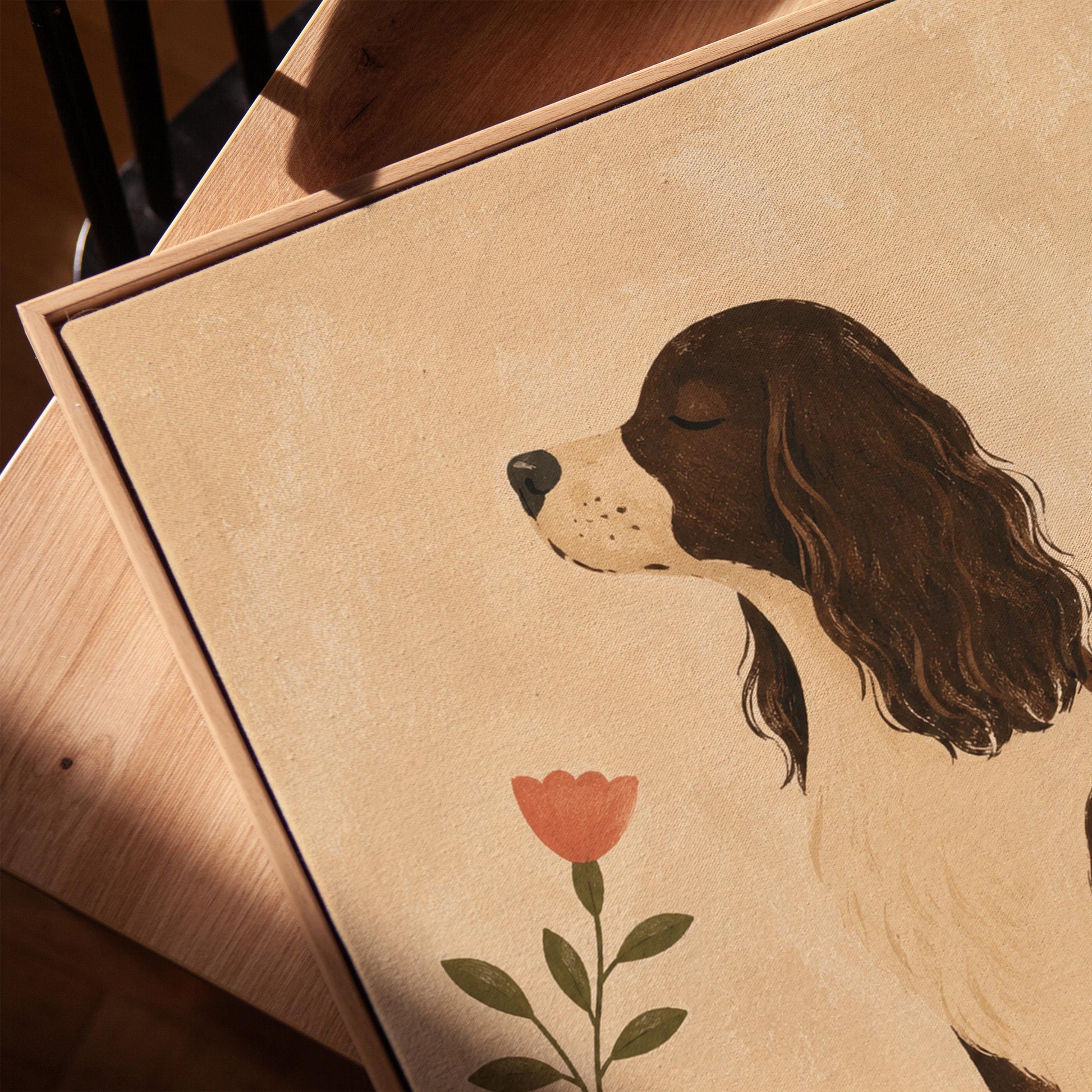 Brown and white spaniel sniffing a coral tulip in a small blue vase, canvas print in a warm, minimally styled interior