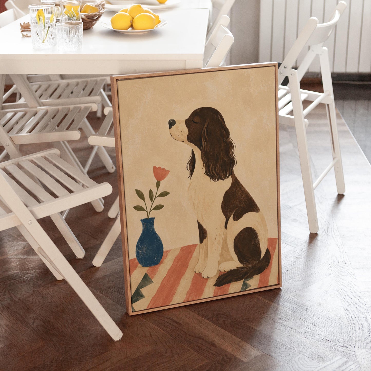 Brown and white spaniel sniffing a coral tulip in a small blue vase, canvas print on a quiet wall in a considered interior