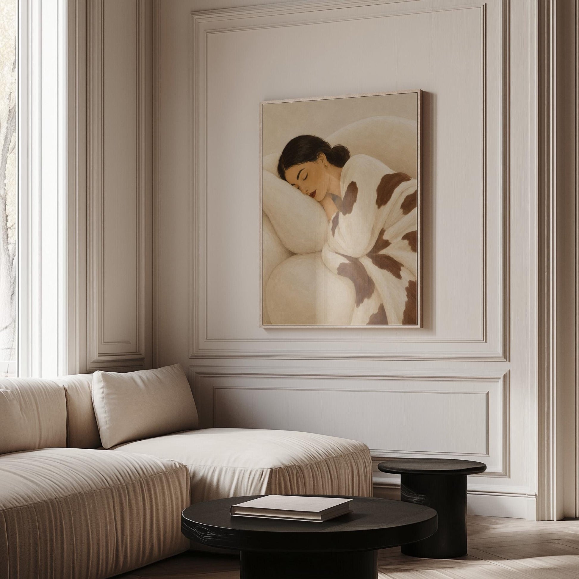 Woman asleep on a pillow under a cream blanket with brown markings, canvas wall art seen in a warm interior with natural light