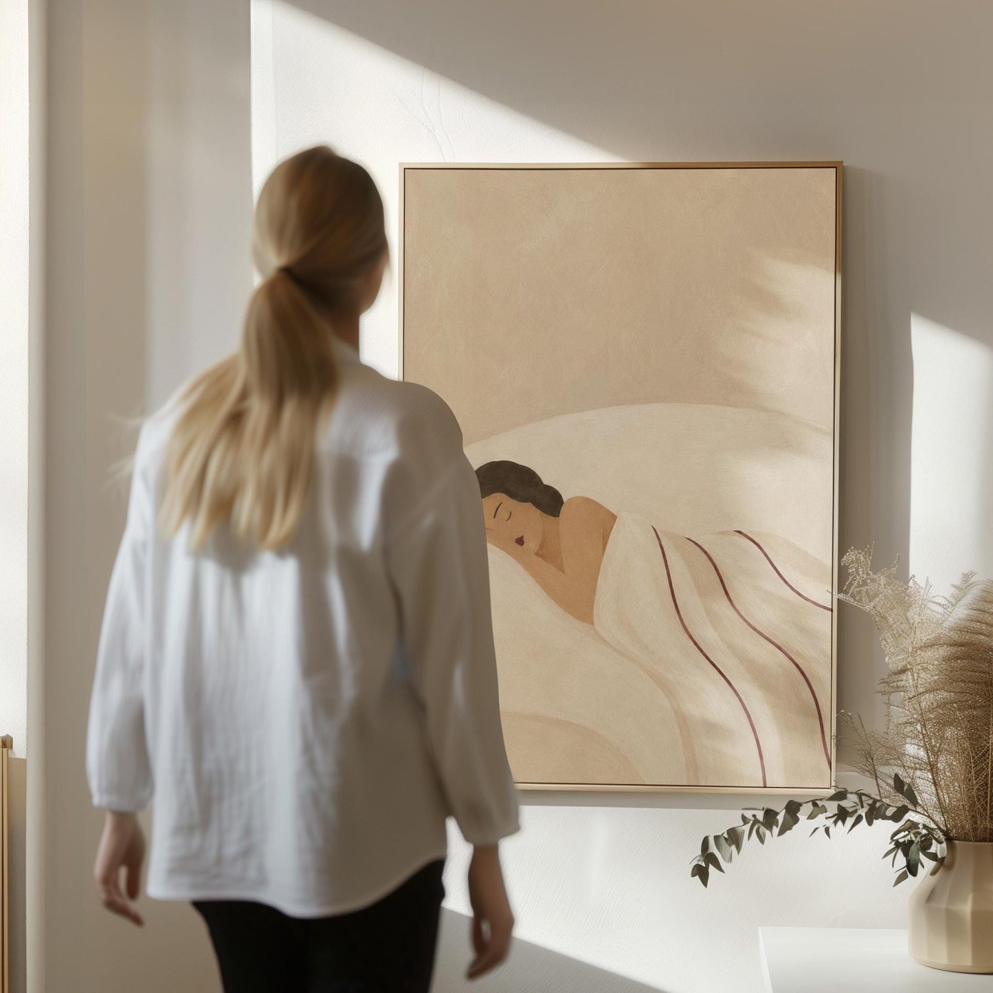 Woman asleep on her side under white linen with thin maroon lines, canvas print shown in a sunlit, contemporary room