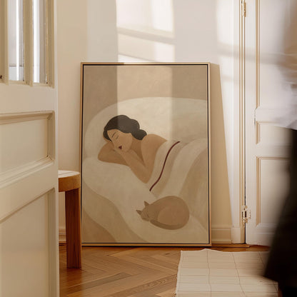 Woman sleeping with a small white cat curled at the foot of the bed, canvas print hanging in a calm, modern living space