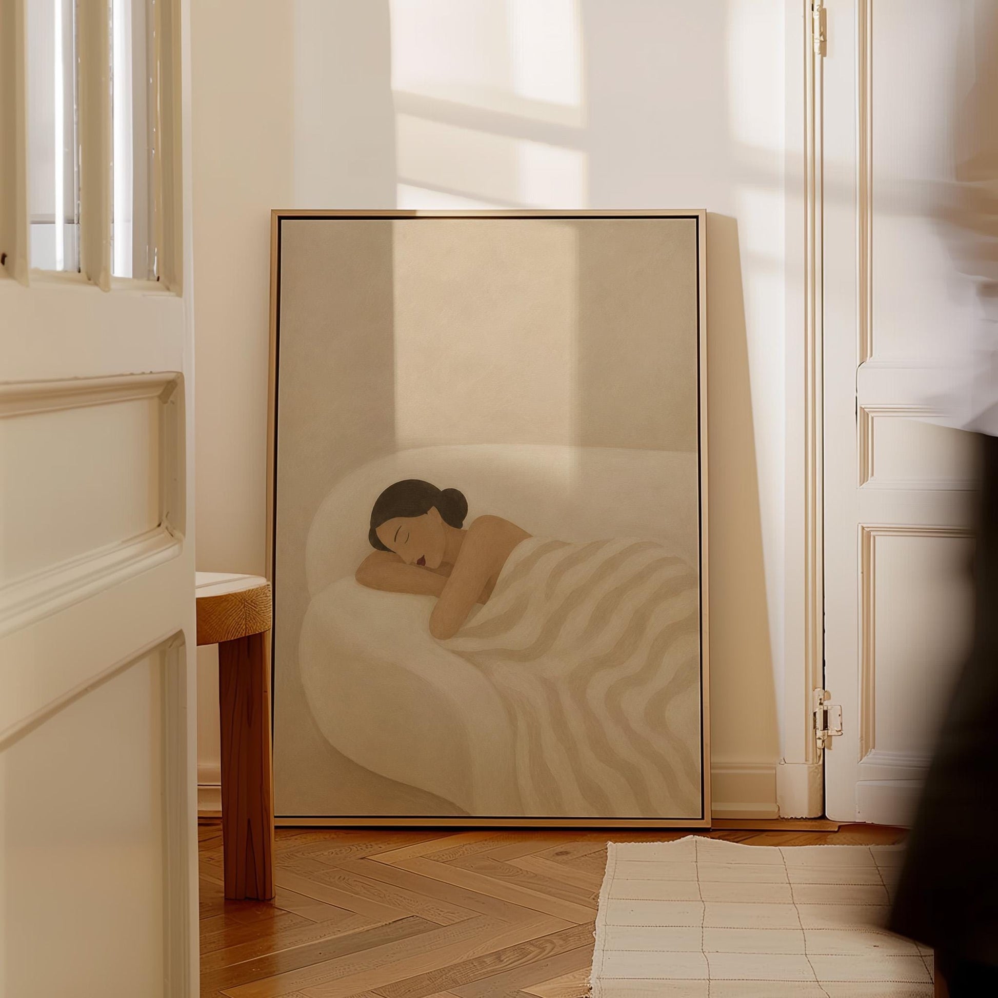 Woman sleeping with hands under her cheek beneath a soft striped quilt, canvas print shown to scale in a furnished room