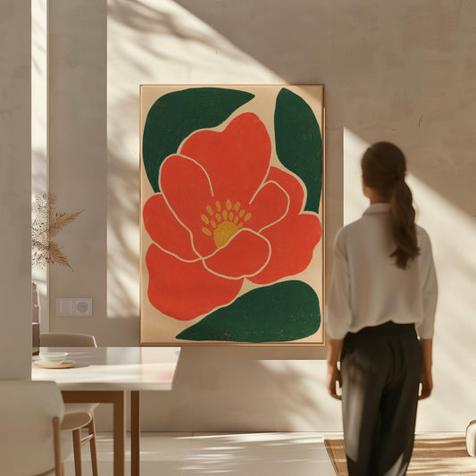 Scarlet flower with gold stamens over deep green leaves on sand, canvas print hanging in a calm, modern living space