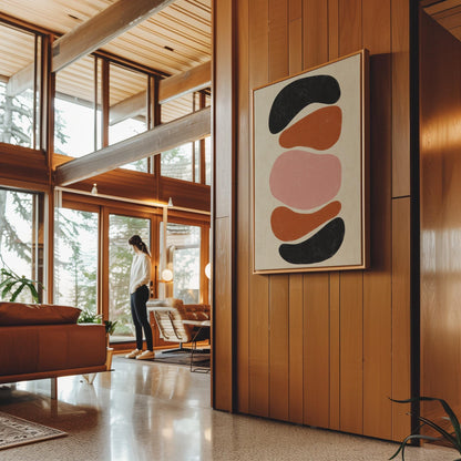 Five stacked pebble shapes in charcoal rust and blush on cream, canvas print shown to scale in a furnished room