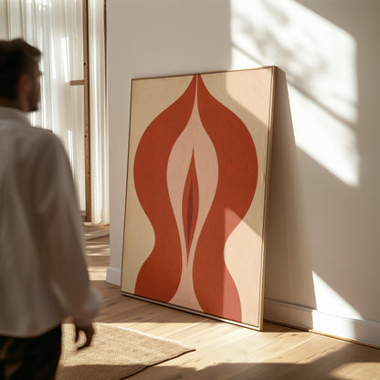 Rust red flame shaped form opening into blush and grey on sand, canvas print displayed on a neutral wall in a styled interior