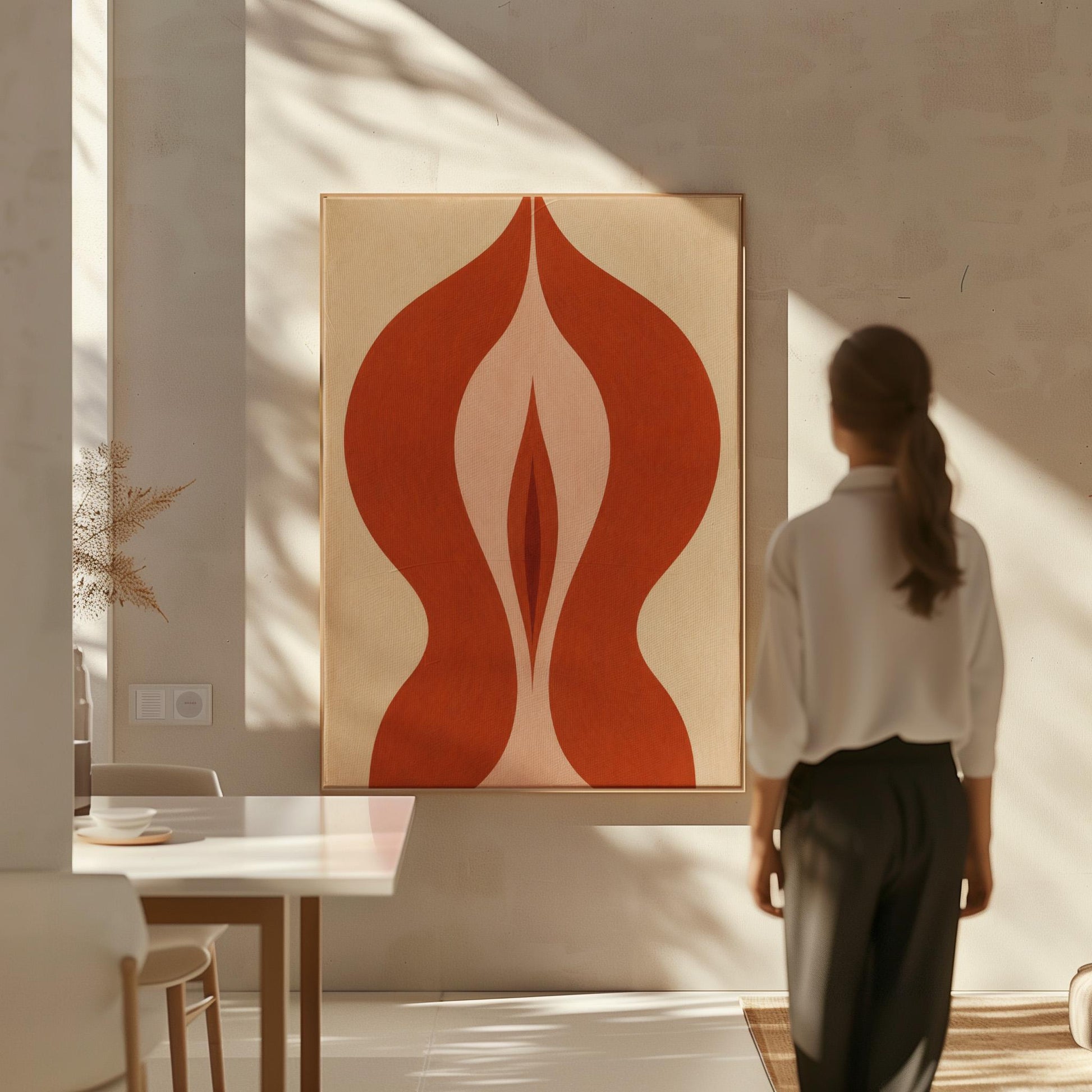 Rust red flame shaped form opening into blush and grey on sand, canvas wall art hanging in a calm, modern living space
