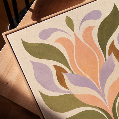 Symmetrical folk tulip motif in olive lilac and peach on cream, canvas print in a warm, minimally styled interior