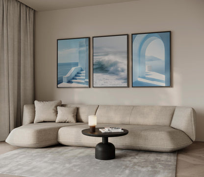 a modern living room with a beige sofa, a round coffee table, and three framed artworks hanging on the wall above the sofa.