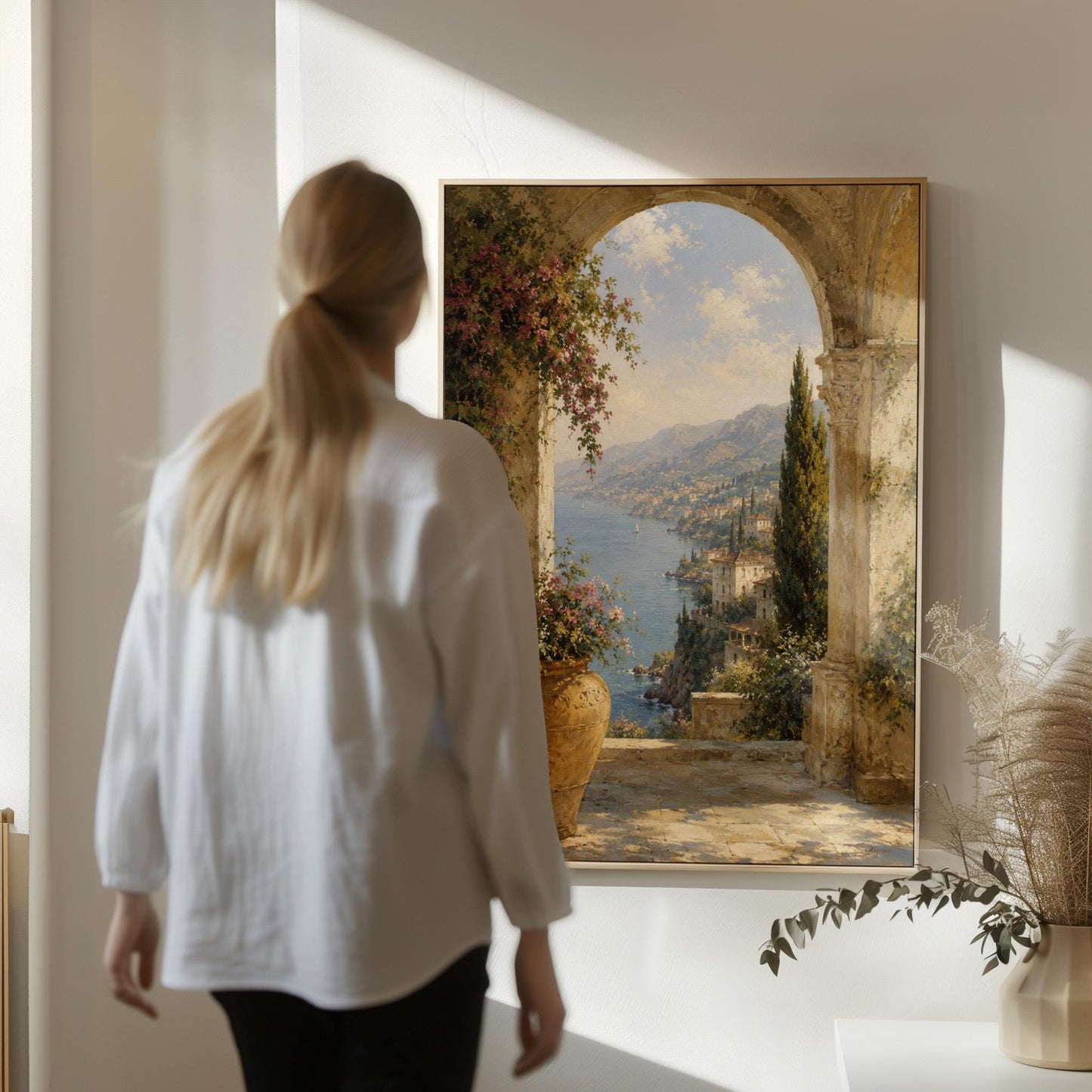 Mediterranean coastline seen through an old stone arch, canvas wall art seen in a warm interior with natural light