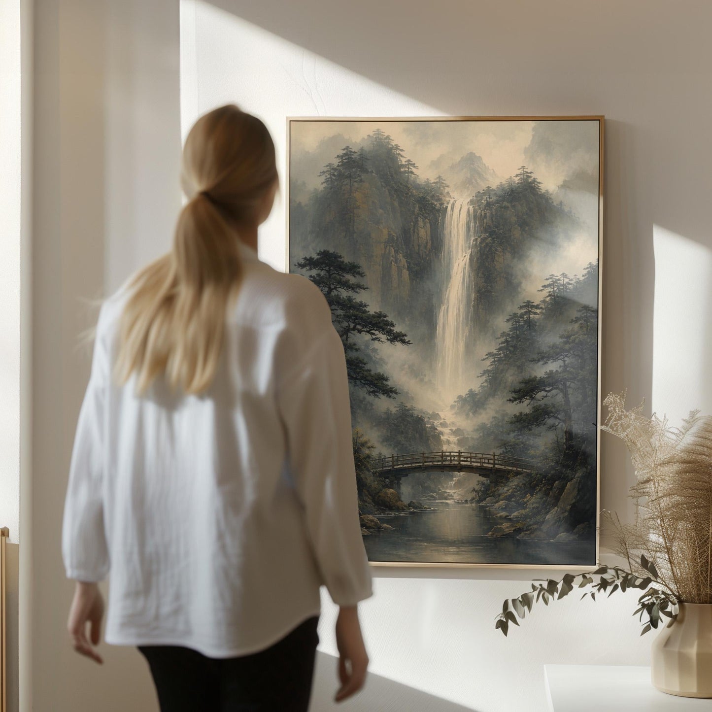Tall waterfall and wooden bridge in a misty gorge, canvas print styled against a soft white wall