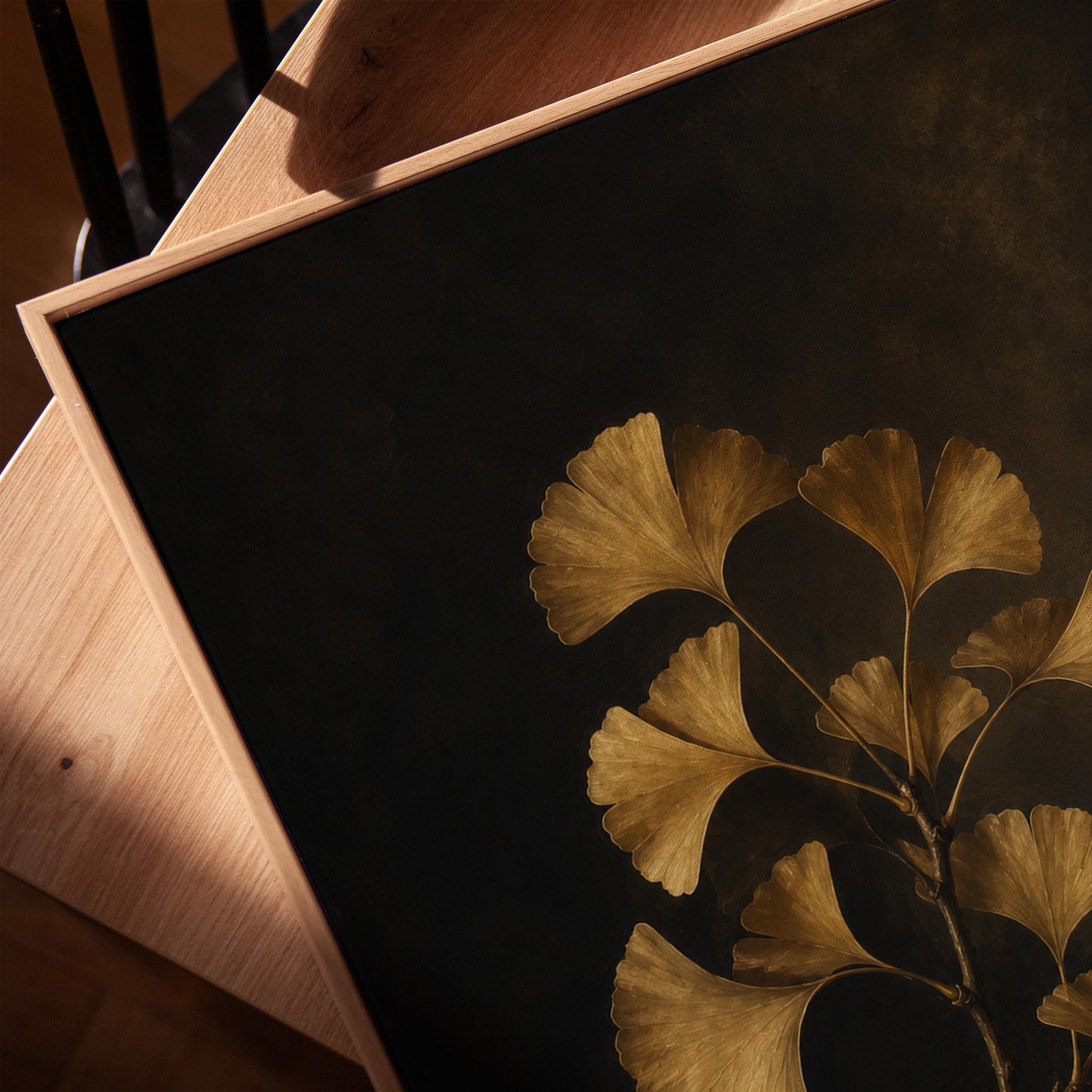 Golden ginkgo branch on a deep charcoal ground, canvas print in a warm, minimally styled interior