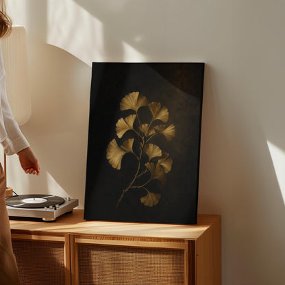 Golden ginkgo branch on a deep charcoal ground, canvas print displayed on a neutral wall in a styled interior
