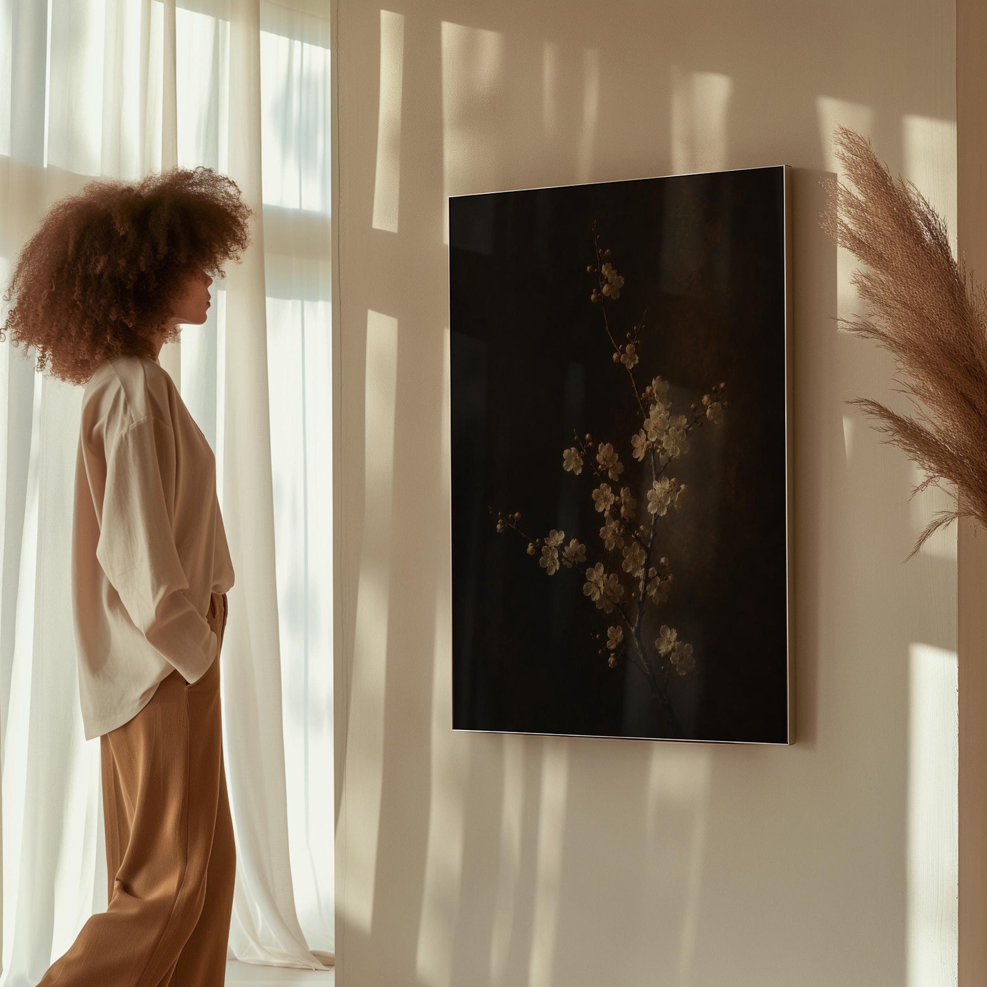 White blossom branch on a dark bronze ground, canvas print displayed on a neutral wall in a styled interior