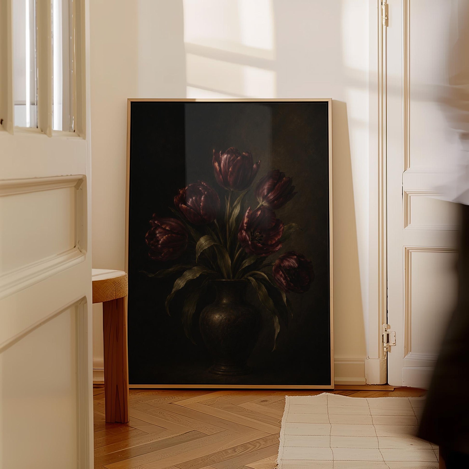 Deep burgundy tulips in a dark metal vase, canvas wall art seen in a warm interior with natural light