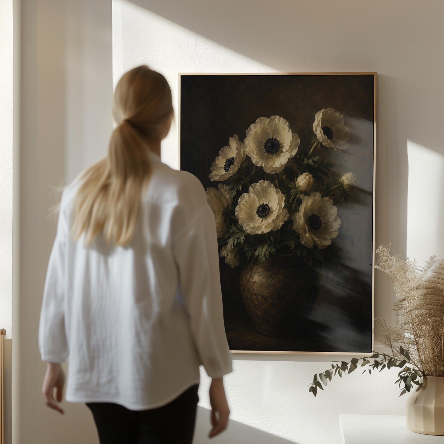 White anemones with dark centres in an earthen vase, canvas print displayed on a neutral wall in a styled interior