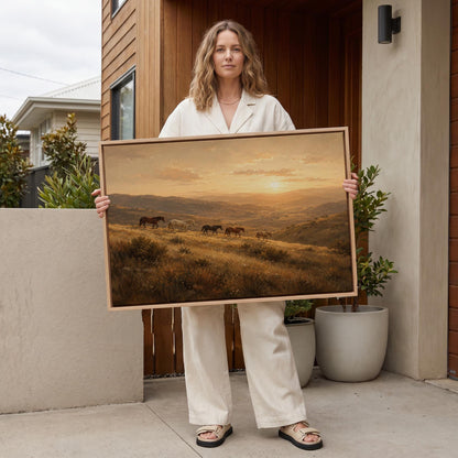 Herd of horses on a hillside trail at golden sunset, canvas print displayed on a neutral wall in a styled interior