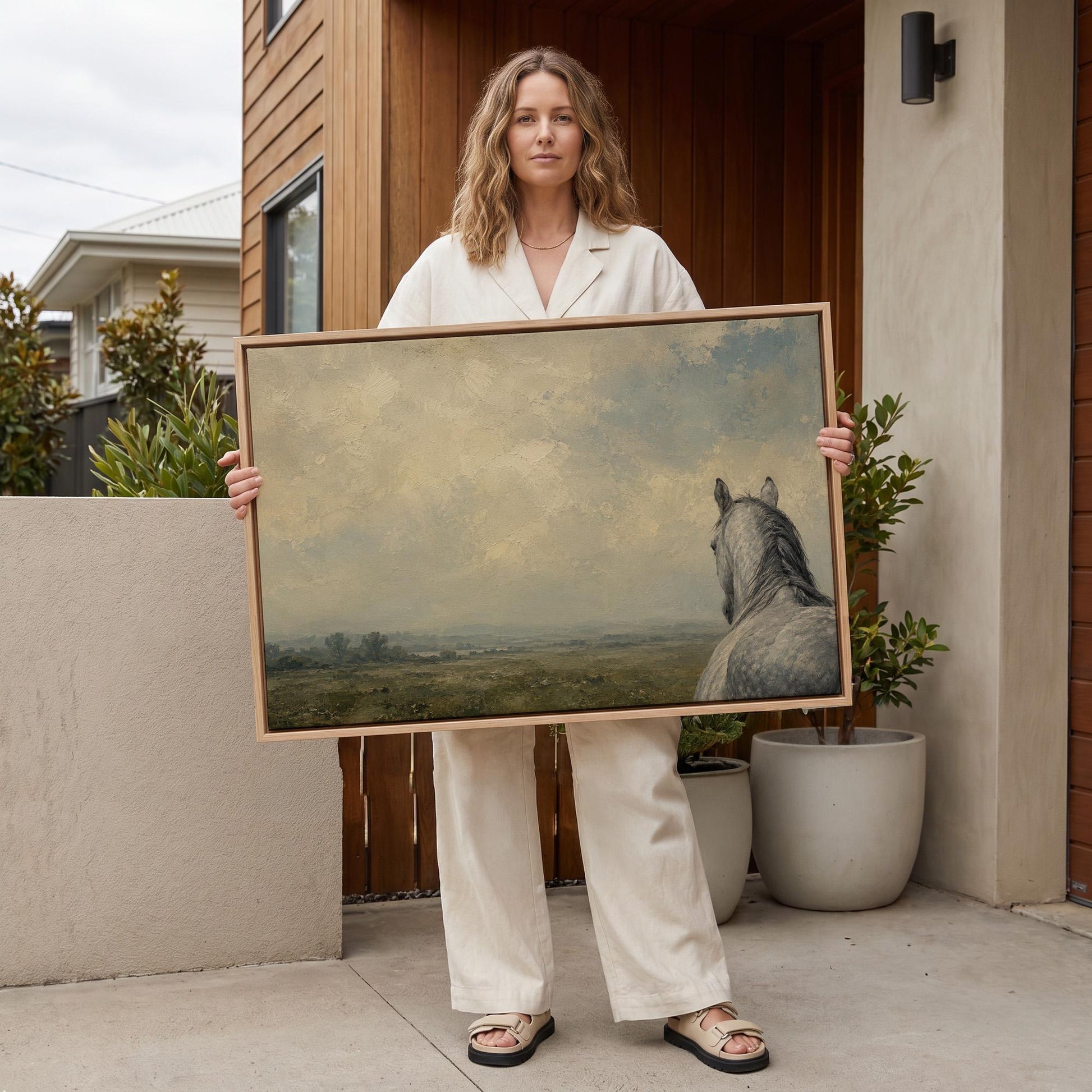 Dapple grey horse looking out over a hazy green valley, canvas wall art styled against a soft white wall
