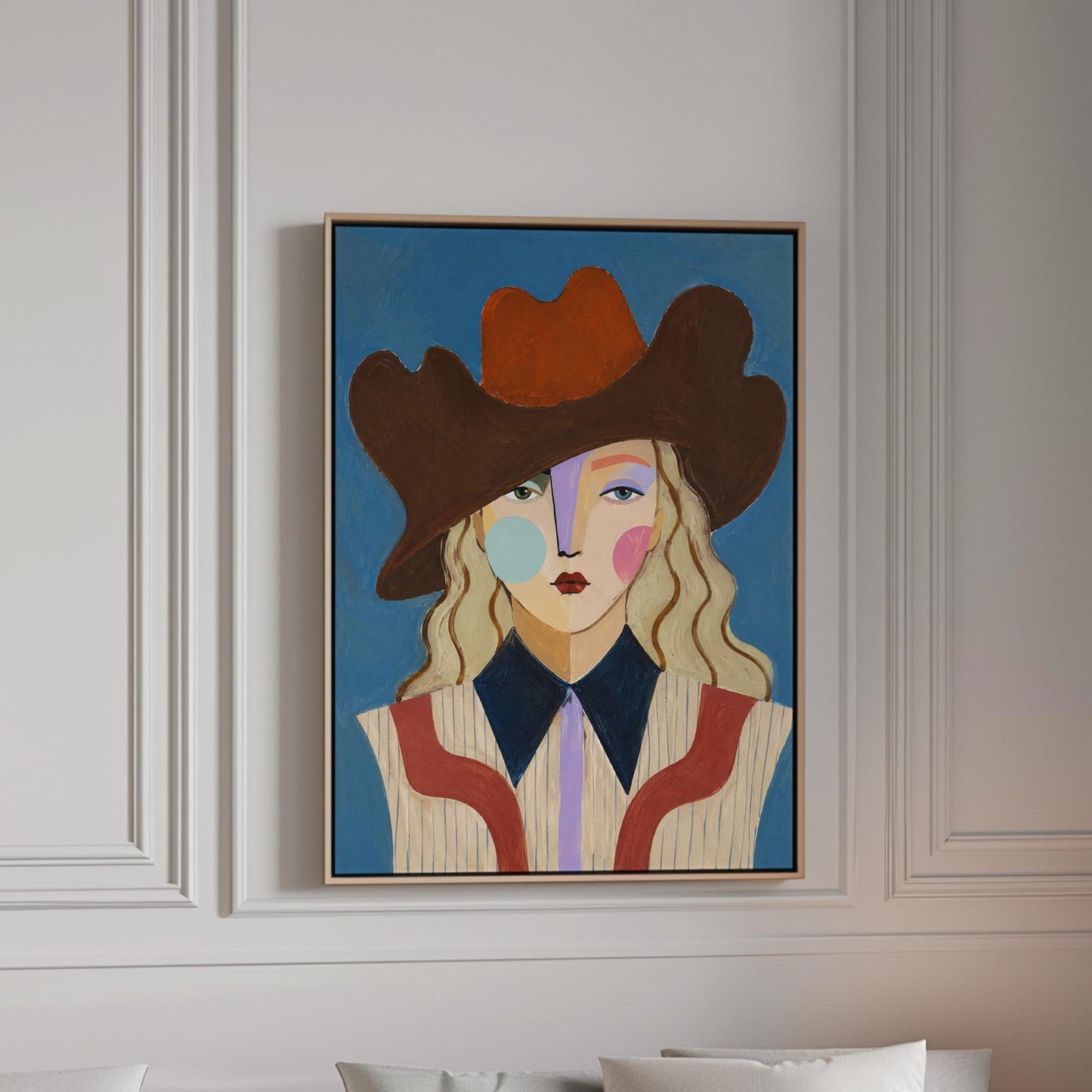 Blonde cowgirl in a rust cowboy hat with a cubist face on deep blue, canvas print in a bright room with natural daylight