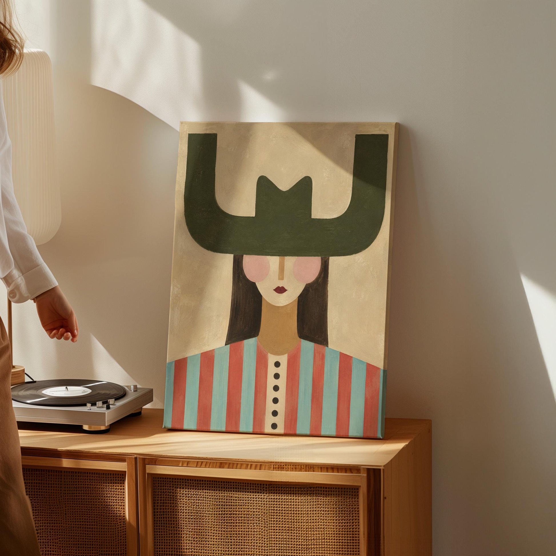 Minimal cowgirl with a bold green hat and red-teal striped shirt on cream, canvas print on a quiet wall in a considered interior