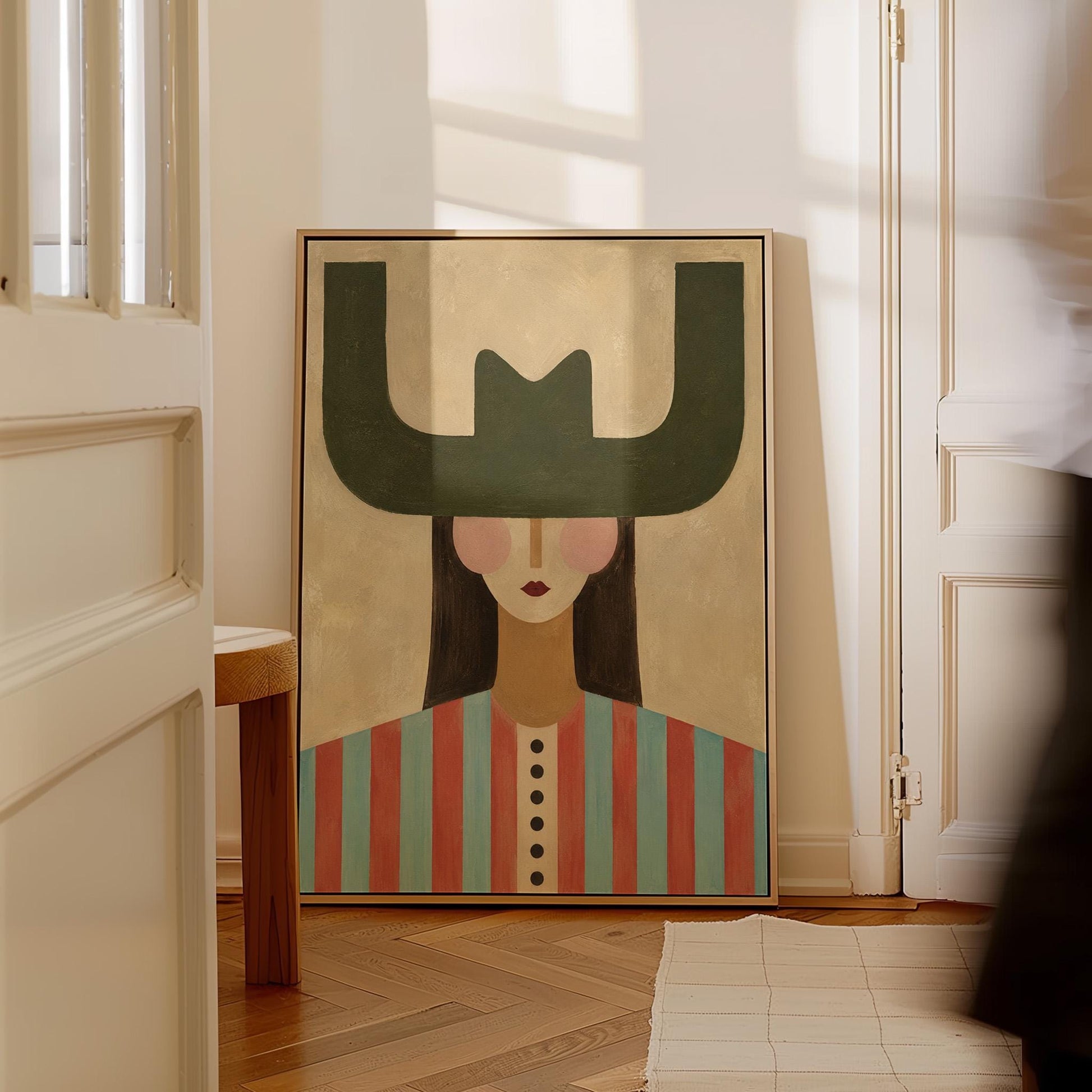 Minimal cowgirl with a bold green hat and red-teal striped shirt on cream, canvas wall art hanging in a calm, modern living space