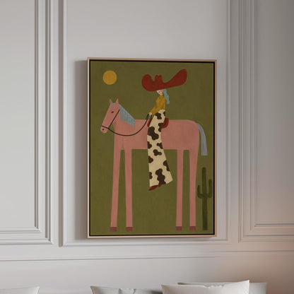 Cowgirl in a red hat riding a long-legged pink horse past a cactus at sunset, canvas print in a bright room with natural daylight