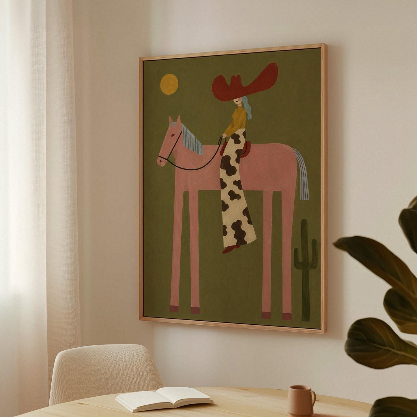 Cowgirl in a red hat riding a long-legged pink horse past a cactus at sunset, canvas wall art presented in a light, minimal room