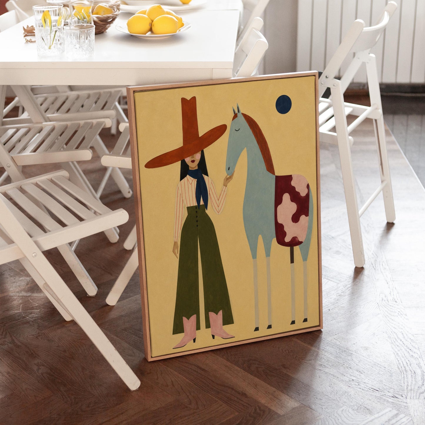Cowgirl in a red hat standing beside a pale blue spotted horse on warm yellow, canvas wall art presented in a light, minimal room
