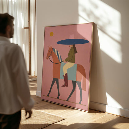 Woman in a wide navy hat riding a chestnut horse in profile on coral pink, canvas print presented in a light, minimal room