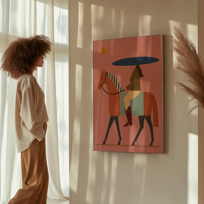 Woman in a wide navy hat riding a chestnut horse in profile on coral pink, canvas print displayed on a neutral wall in a styled interior