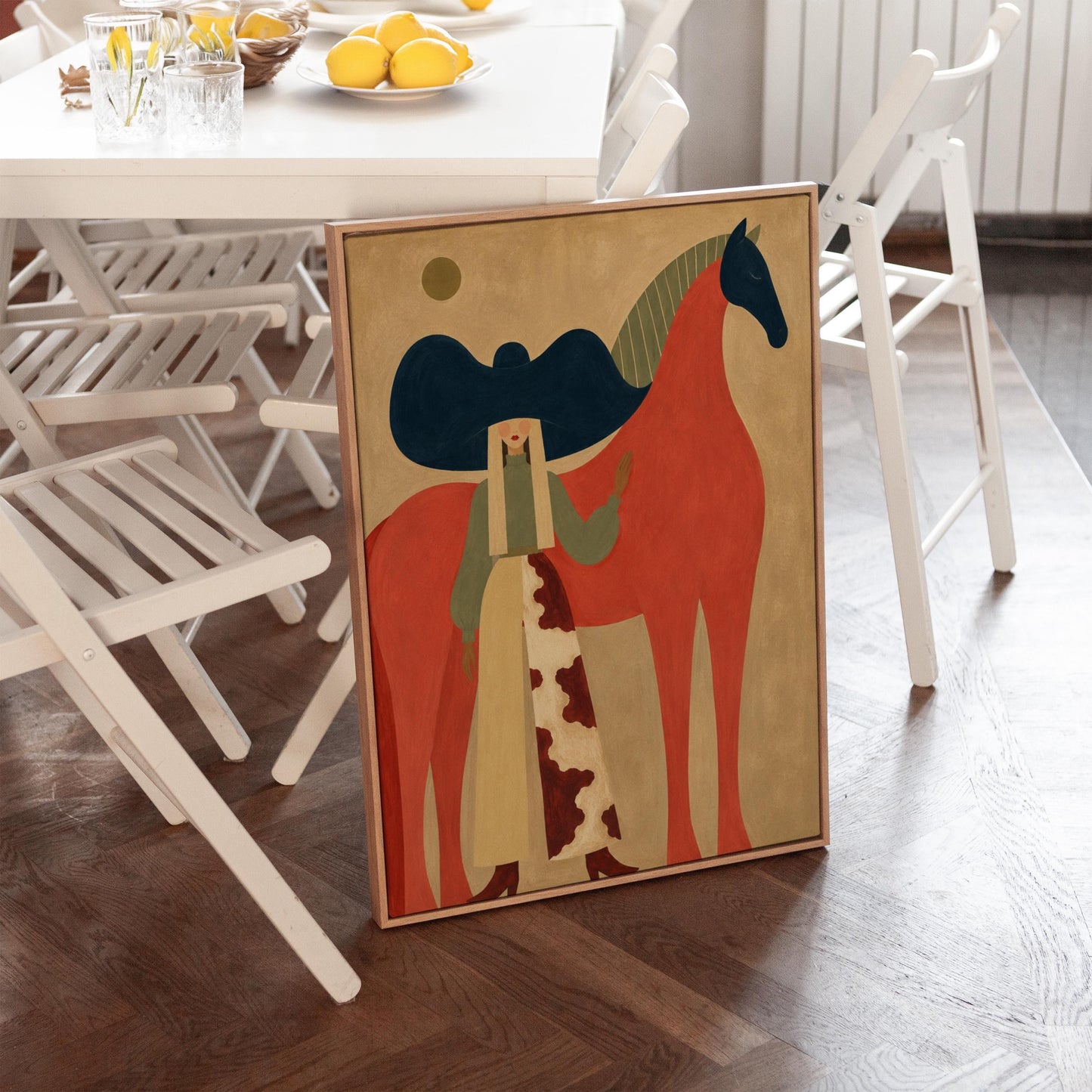 Woman in a big navy hat standing before a bright red horse on warm ochre, canvas wall art styled against a soft white wall