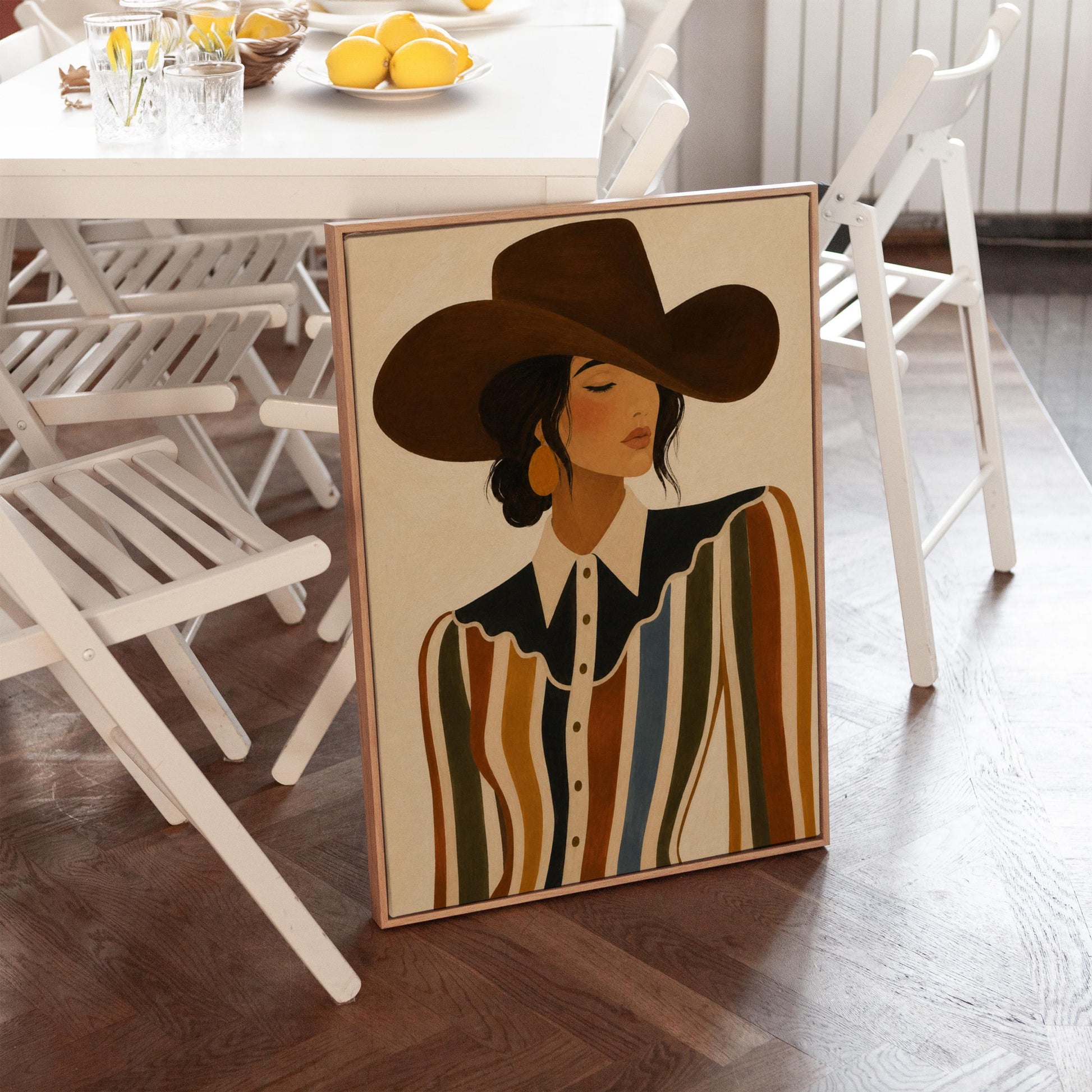 Cowgirl in a brown hat and rippling striped blouse with a black collar on cream, canvas print shown in a sunlit, contemporary room