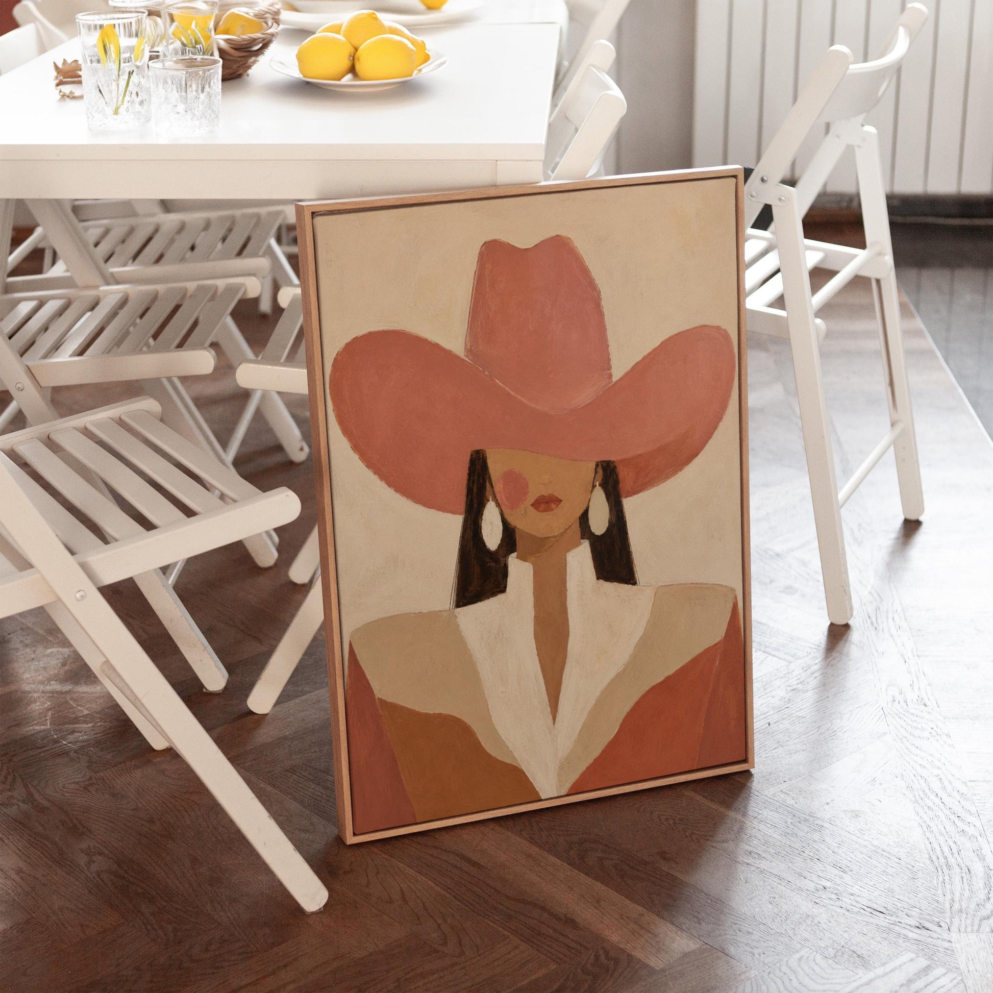 Minimal cowgirl in a coral hat and white collar with dark hair on cream, canvas print presented in a light, minimal room