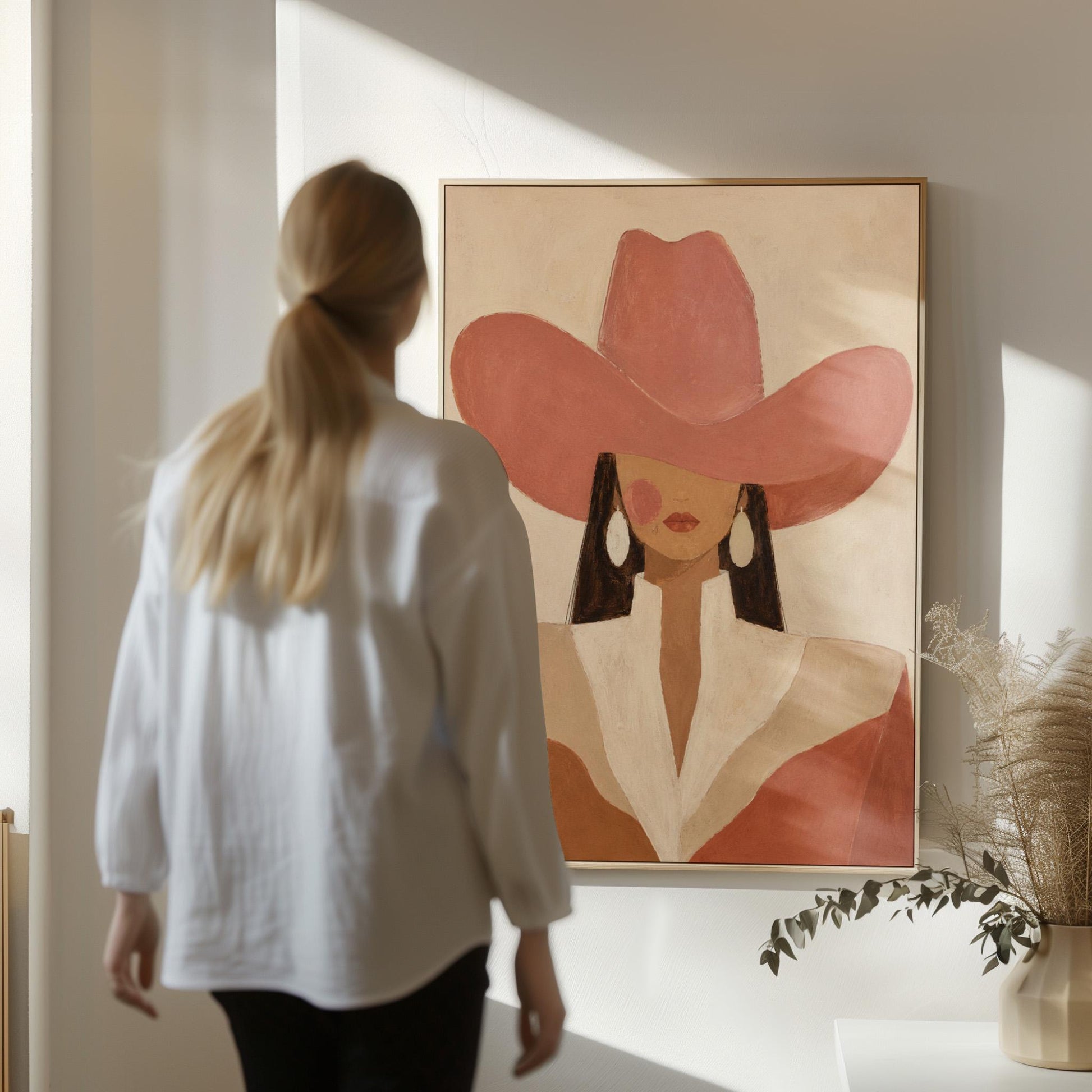 Minimal cowgirl in a coral hat and white collar with dark hair on cream, canvas wall art styled against a soft white wall