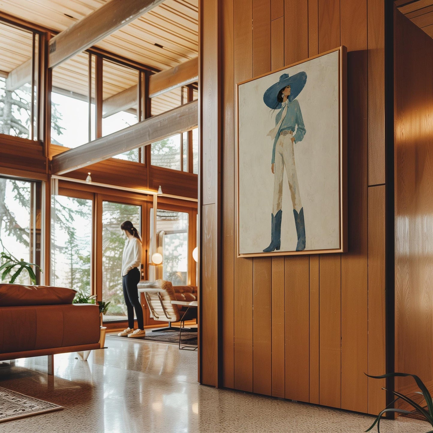 Full-figure cowgirl in a wide teal hat, blouse and boots with cream trousers, canvas print displayed on a neutral wall in a styled interior