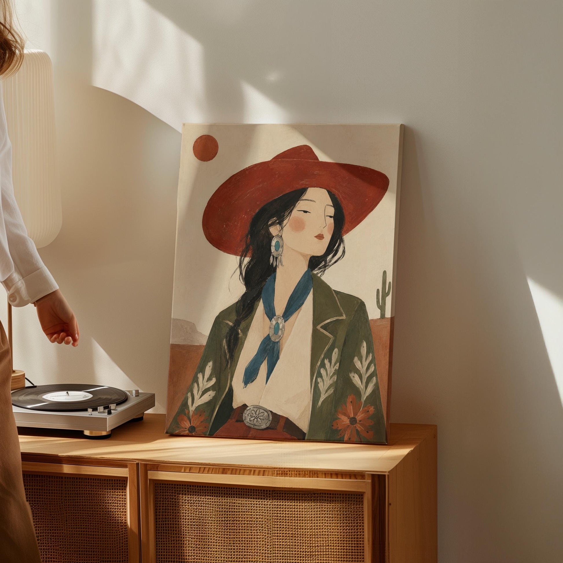 Cowgirl in a red hat and embroidered jacket with turquoise jewelry in the desert, canvas wall art seen in a warm interior with natural light
