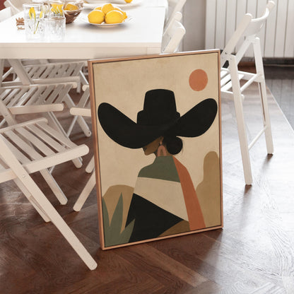Cowgirl seen from behind in a large black hat and serape under a desert sun, canvas print styled against a soft white wall