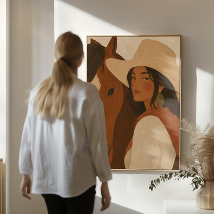 Cowgirl in a cream hat leaning cheek to cheek with a chestnut horse on warm tan, canvas wall art hanging in a calm, modern living space