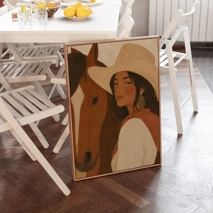 Cowgirl in a cream hat leaning cheek to cheek with a chestnut horse on warm tan, canvas wall art seen in a warm interior with natural light