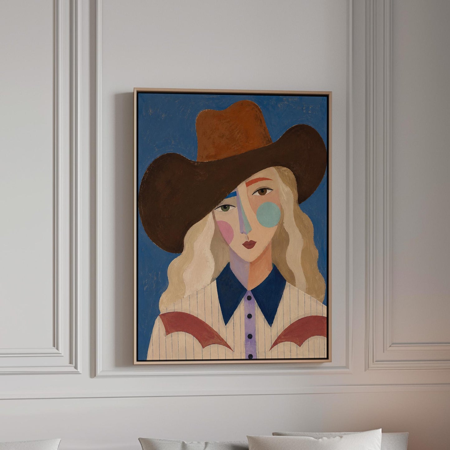 Blonde cowgirl in a rust hat with a cubist pastel face on deep blue, canvas print in a bright room with natural daylight