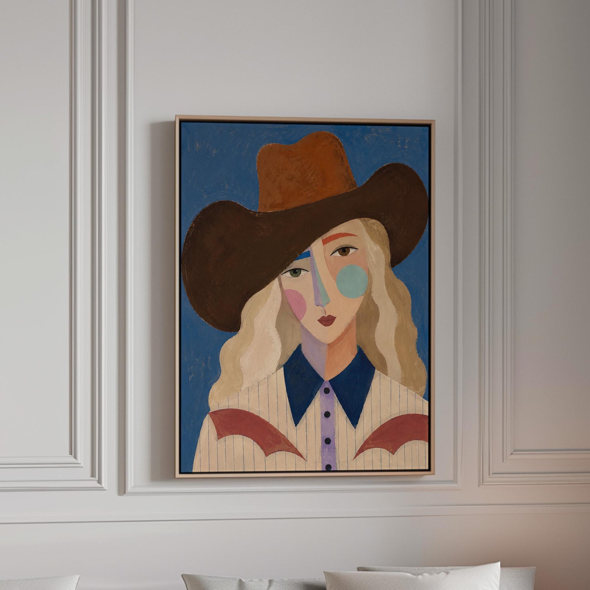 Blonde cowgirl in a rust hat with a cubist pastel face on deep blue, canvas print in a bright room with natural daylight