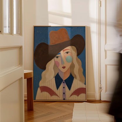 Blonde cowgirl in a rust hat with a cubist pastel face on deep blue, canvas print seen in a warm interior with natural light