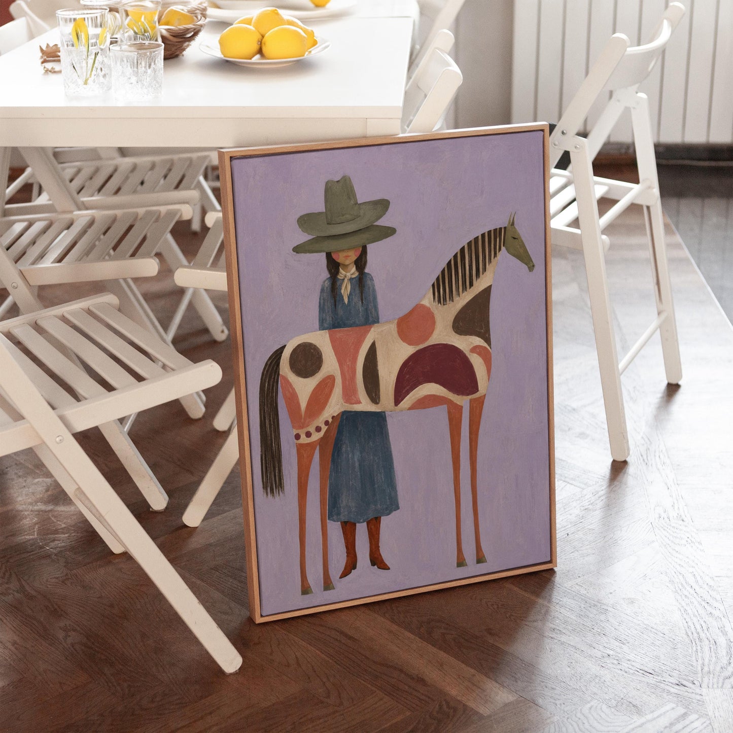 Woman in an olive hat before a patterned folk horse on a lavender ground, canvas print shown to scale in a furnished room