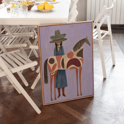 Woman in an olive hat before a patterned folk horse on a lavender ground, canvas print shown to scale in a furnished room