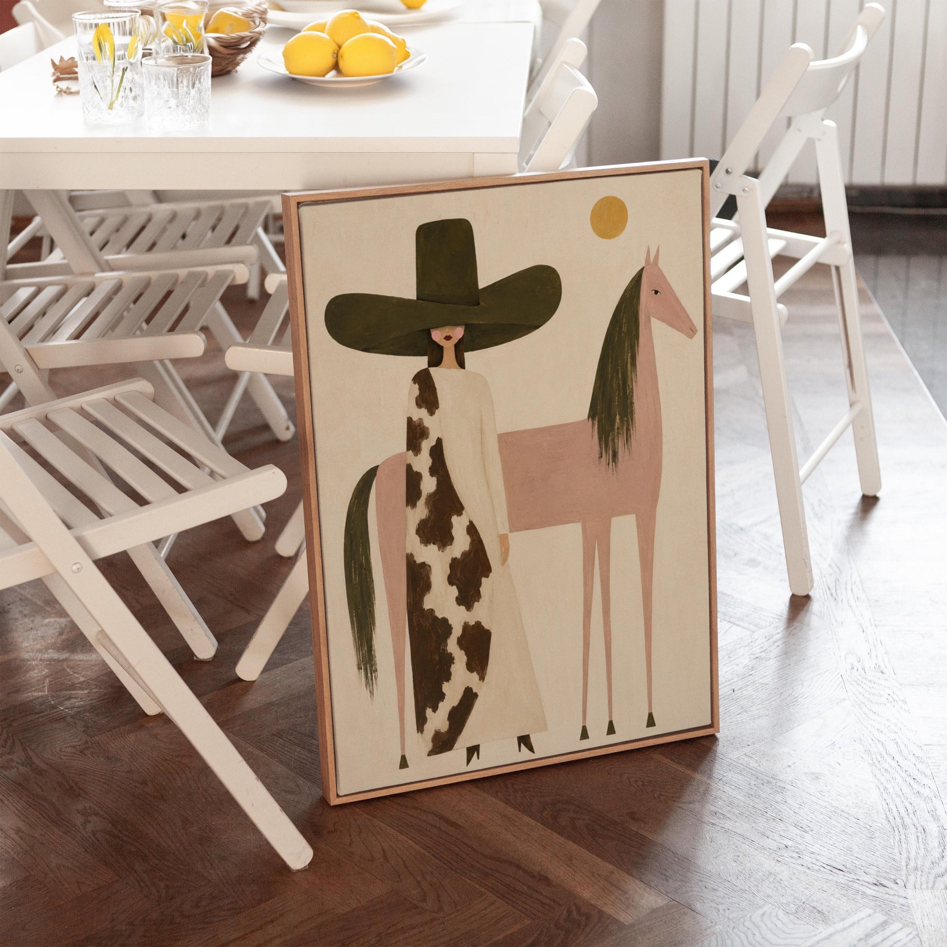 Woman in a tall dark hat standing beside a soft pink horse with olive mane, canvas print shown in a sunlit, contemporary room