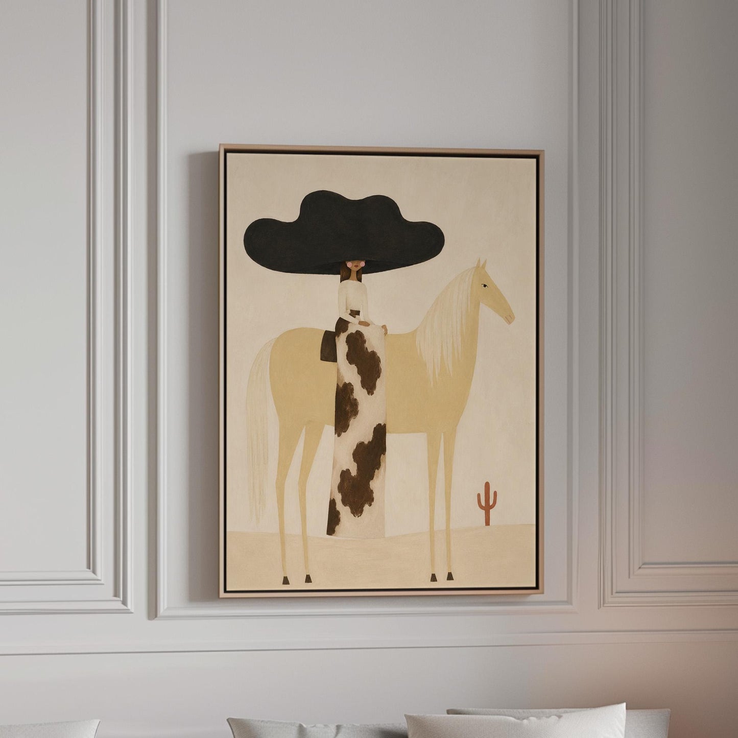 Woman in a huge black hat riding a pale palomino across a desert with cactus, canvas print in a bright room with natural daylight