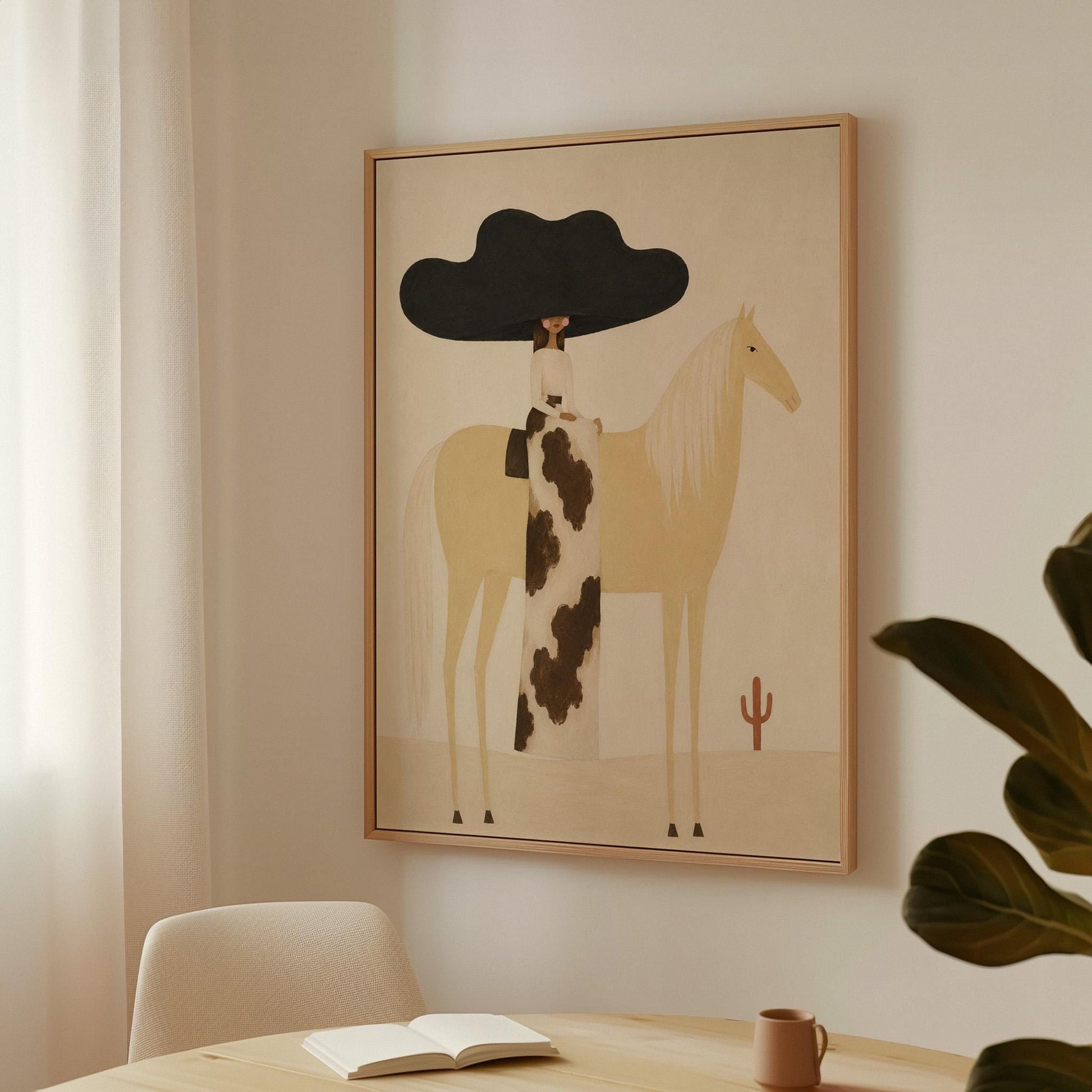 Woman in a huge black hat riding a pale palomino across a desert with cactus, canvas print shown to scale in a furnished room