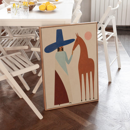 Woman in a tall blue hat reaching to a slim chestnut horse under a pink sun, canvas print styled against a soft white wall