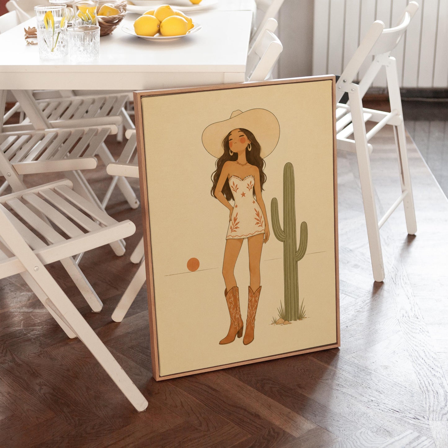 Cowgirl in a white dress and boots beside a saguaro cactus at desert sunset, canvas print shown to scale in a furnished room
