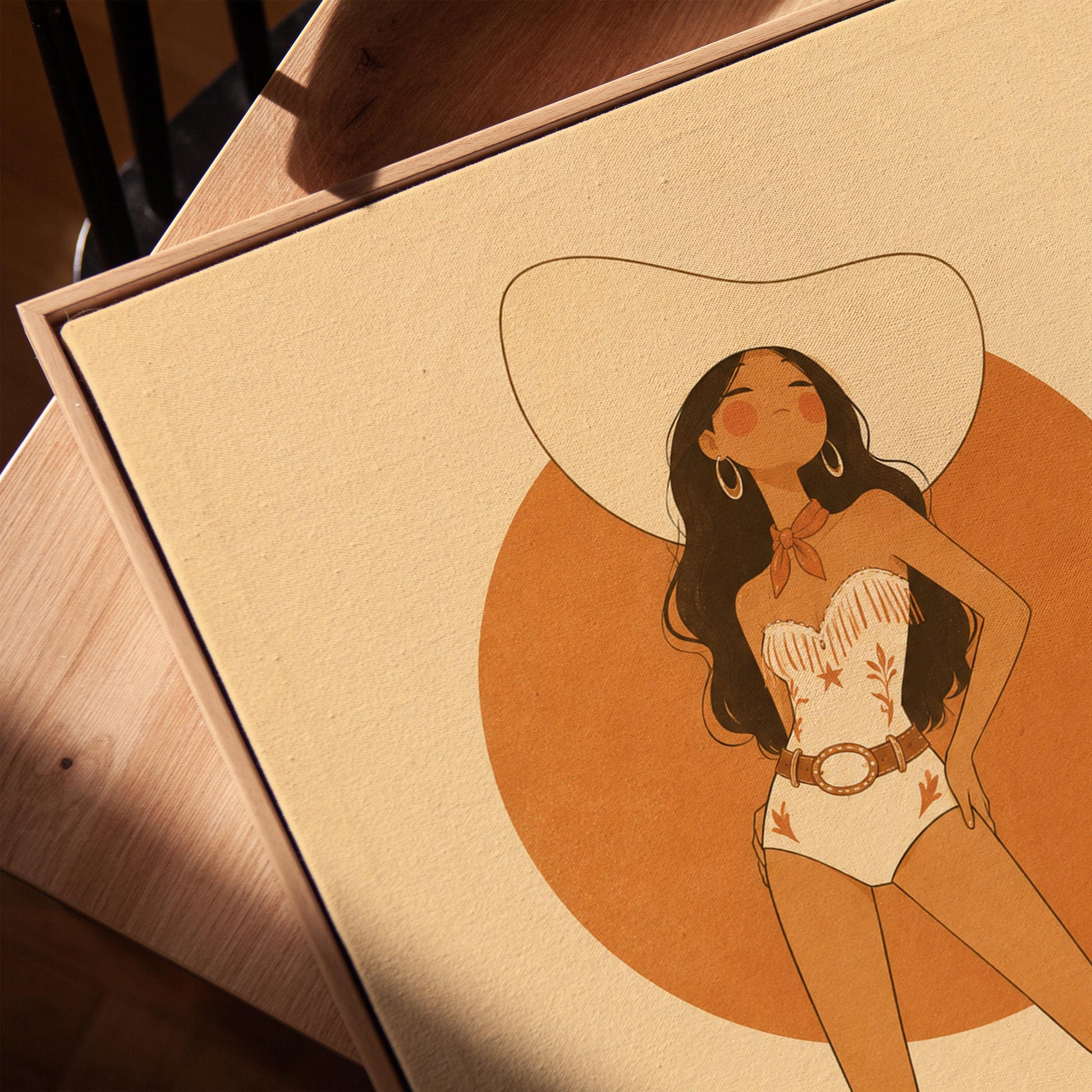 Cowgirl in a white star bodysuit against a large burnt orange sun disc, canvas print in a warm, minimally styled interior