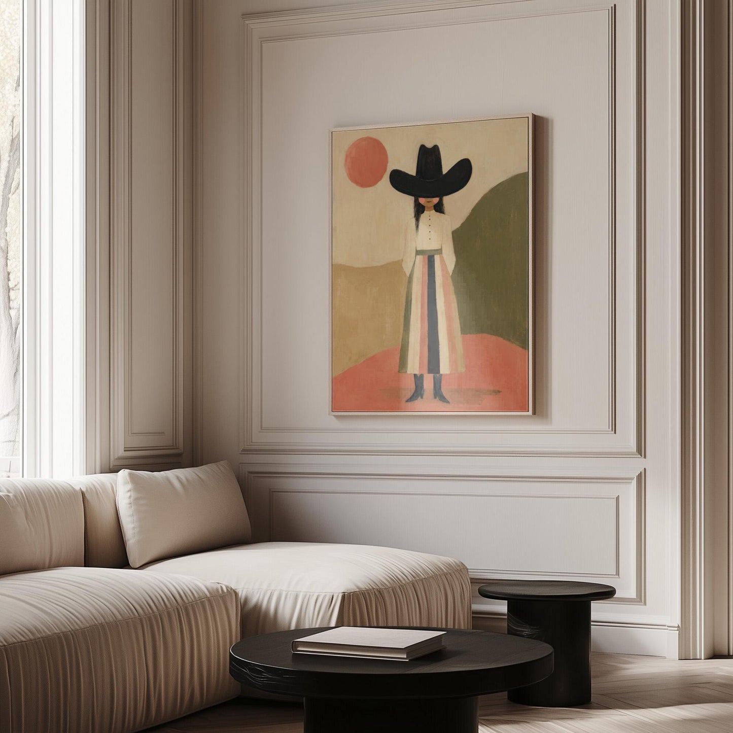 Figure in black cowboy hat standing between coral desert hills, canvas print displayed on a neutral wall in a styled interior